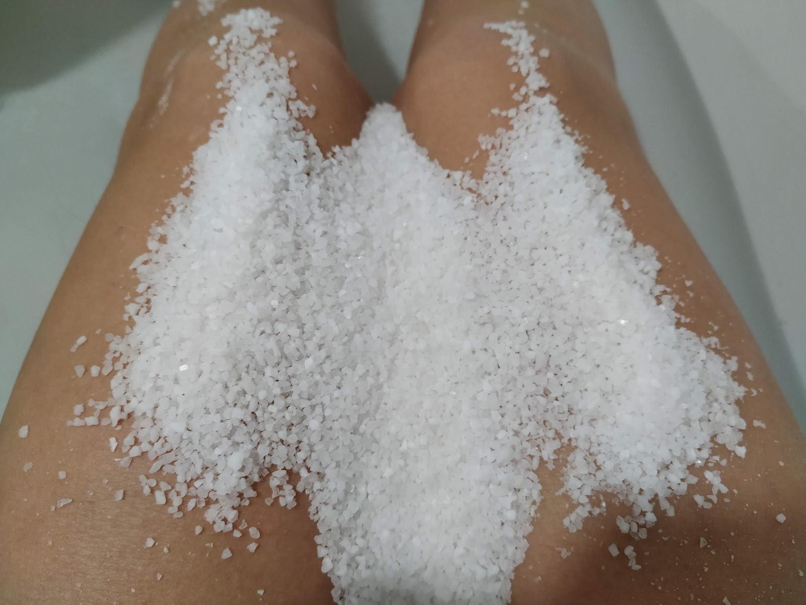 Sal gruesa para baños sobre las piernas, dentro de la bañera
